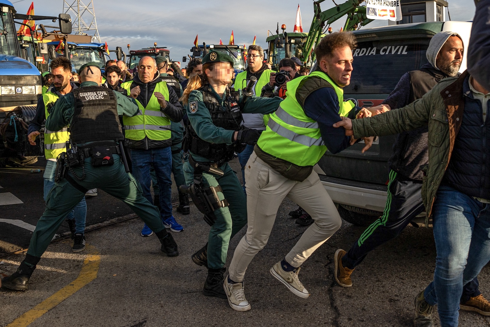 epa11169153 Civil Guard officers clash with Spanish farmers as they block the A-42 state highway before marching to downtown Madrid, near the village of Torrejon de la Calzada, Madrid region, Spain, 21 February 2024.  After two weeks of protests, about 500 tractors and agricultural vehicles are expected to surround the capital, and march towards the Ministry of Agriculture in downtown Madrid.  EPA/DANIEL GONZALEZ PIXELATION FROM SOURCE TO COMPLY WITH SPANISH LAW