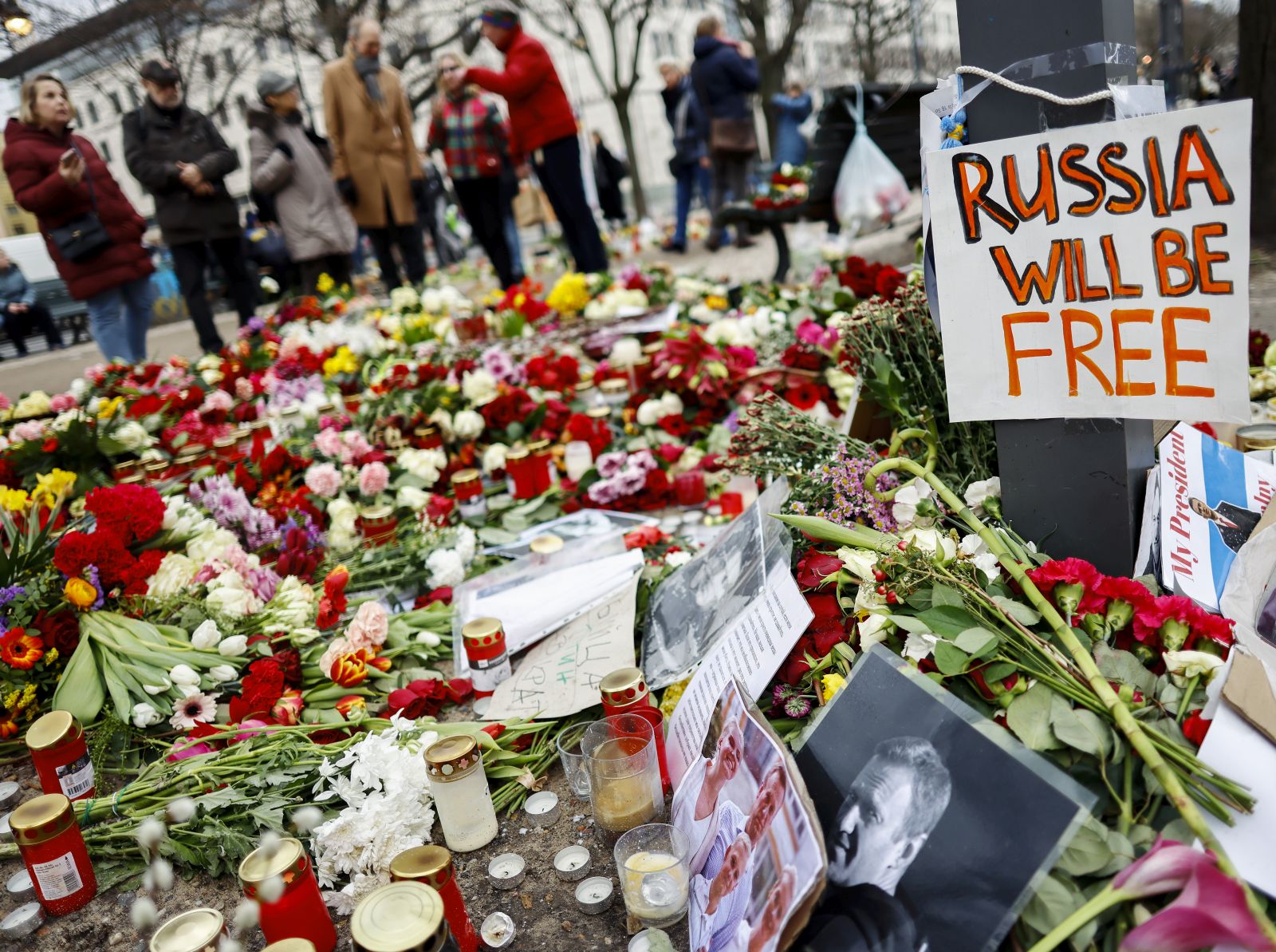 epa11170435 A photo showing late Russian opposition leader Alexei Navalny sits among floral tributes outside the Russian embassy in Berlin, Germany, 21 February 2024. Outspoken Kremlin critic Alexei Navalny died in a penal colony, the Federal Penitentiary Service of the Yamalo-Nenets Autonomous District announced on 16 February 2024. In late 2023 Navalny was transferred to an Arctic penal colony, considered one of the harshest prisons.  EPA/HANNIBAL HANSCHKE