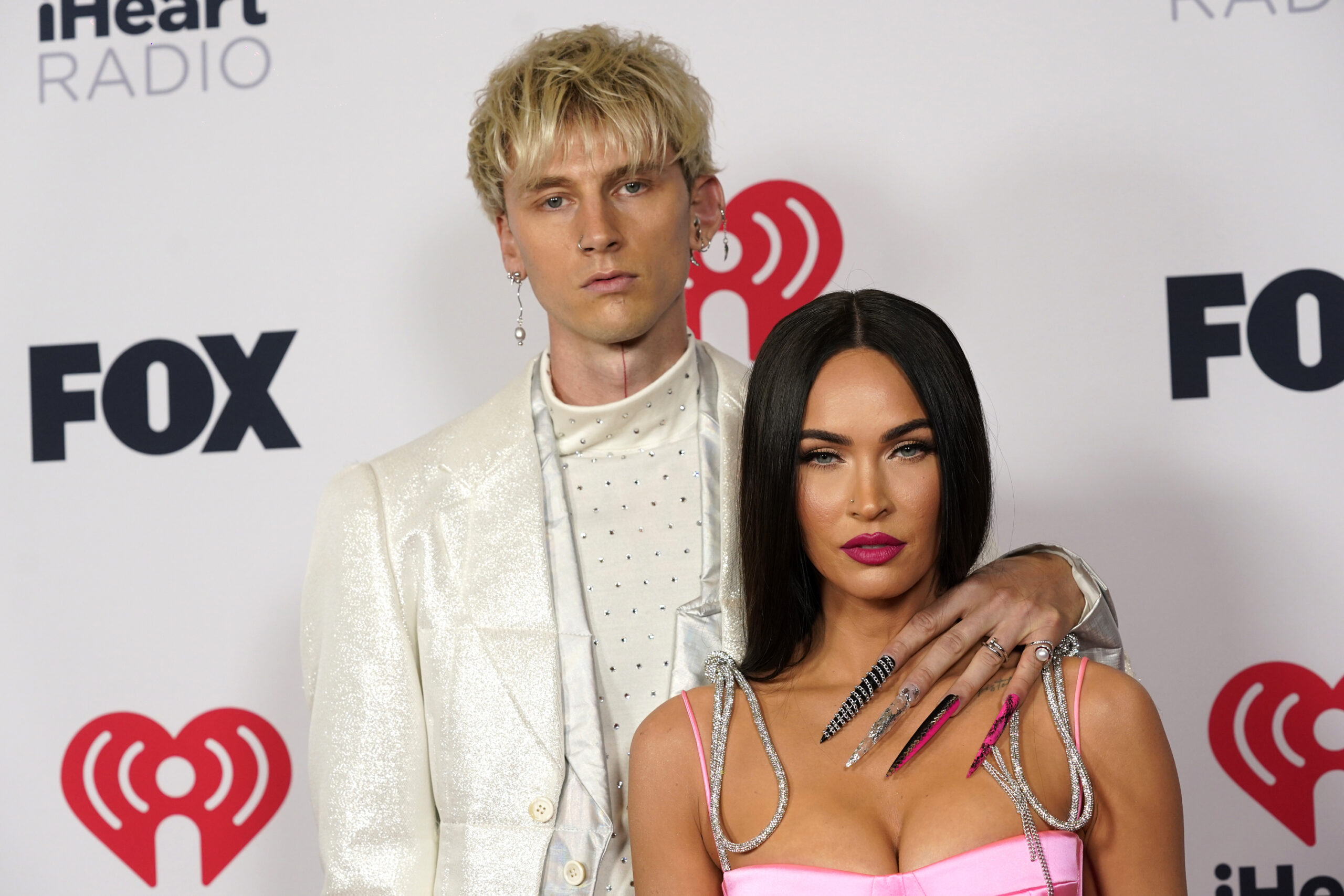 FILE - Megan Fox, right, and Machine Gun Kelly attend the iHeartRadio Music Awards on May 27, 2021, in Los Angeles. Fox and Kelly are engaged. The actor and rapper have decided to legalize their dramatically eccentric coupling, according to Instagram videos that each posted Wednesday, Jan. 12, 2022.  (AP Photo/Chris Pizzello, File)