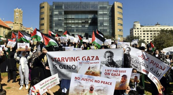epa11188069 Palestinian protesters carry placards and Palestinian flags during a protest in solidarity with the Palestinian people under the slogan 'Starving Gaza is genocide' outside the United Nations Economic and Social Commission for Western Asia (UN-ESCWA) headquarters in Beirut, Lebanon, 29 February 2024. Thousands of Israelis and Palestinians have been killed since the militant group Hamas launched an unprecedented attack on Israel from the Gaza Strip on 07 October 2023, and the Israeli strikes on the Palestinian enclave which followed it.  EPA/WAEL HAMZEH