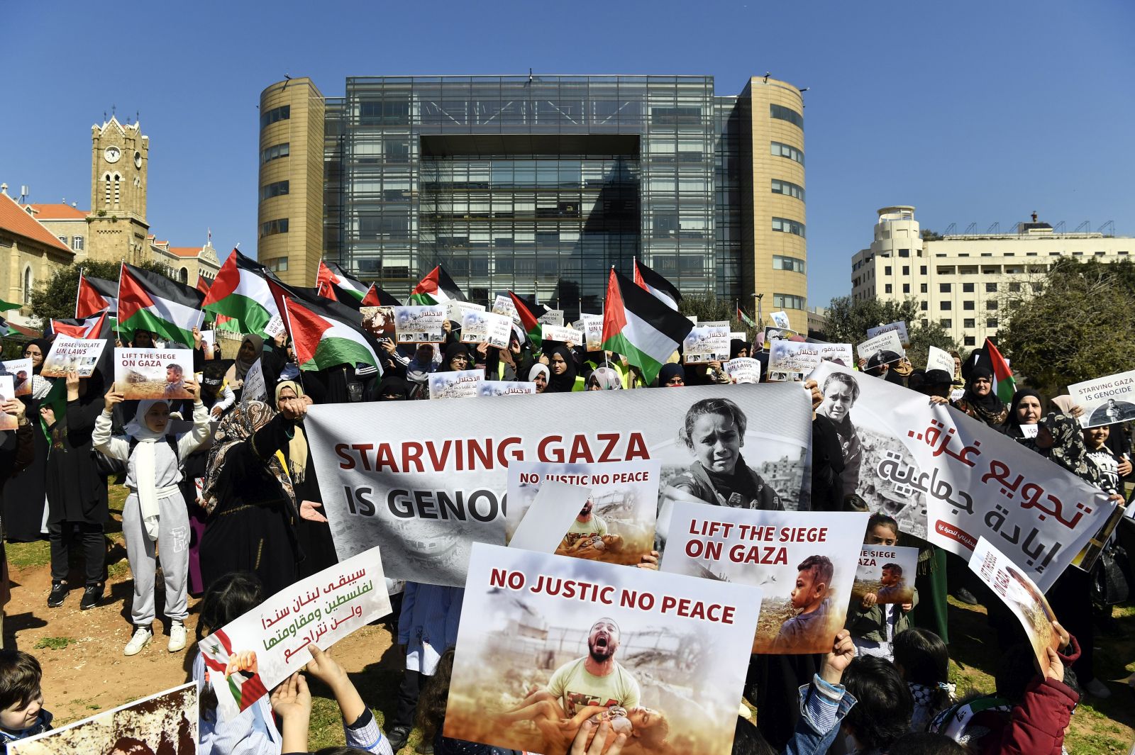 epa11188069 Palestinian protesters carry placards and Palestinian flags during a protest in solidarity with the Palestinian people under the slogan 'Starving Gaza is genocide' outside the United Nations Economic and Social Commission for Western Asia (UN-ESCWA) headquarters in Beirut, Lebanon, 29 February 2024. Thousands of Israelis and Palestinians have been killed since the militant group Hamas launched an unprecedented attack on Israel from the Gaza Strip on 07 October 2023, and the Israeli strikes on the Palestinian enclave which followed it.  EPA/WAEL HAMZEH