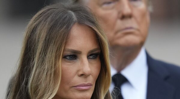 Former President Donald Trump stands behind his wife Melania as she watches pallbearers carry the coffin of her mother, Amalija Knavs, Thursday, Jan. 18, 2024, at the Church of Bethesda-by-the-Sea in Palm Beach, Fla. (AP Photo/Rebecca Blackwell)