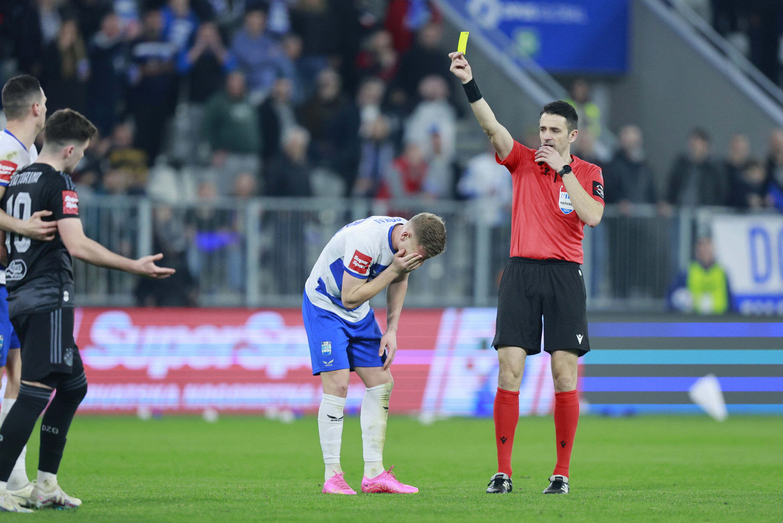 03.03.2024., Opus Arena, Osijek - SuperSport prva Hrvatska nogometna liga, 25. kolo, NK Osijek - GNK Dinamo. Sudac Igor Pajac pokazuje zuti karton nogometasu Osijeka Enisu Cokaju. Photo: Davor Javorovic/PIXSELL