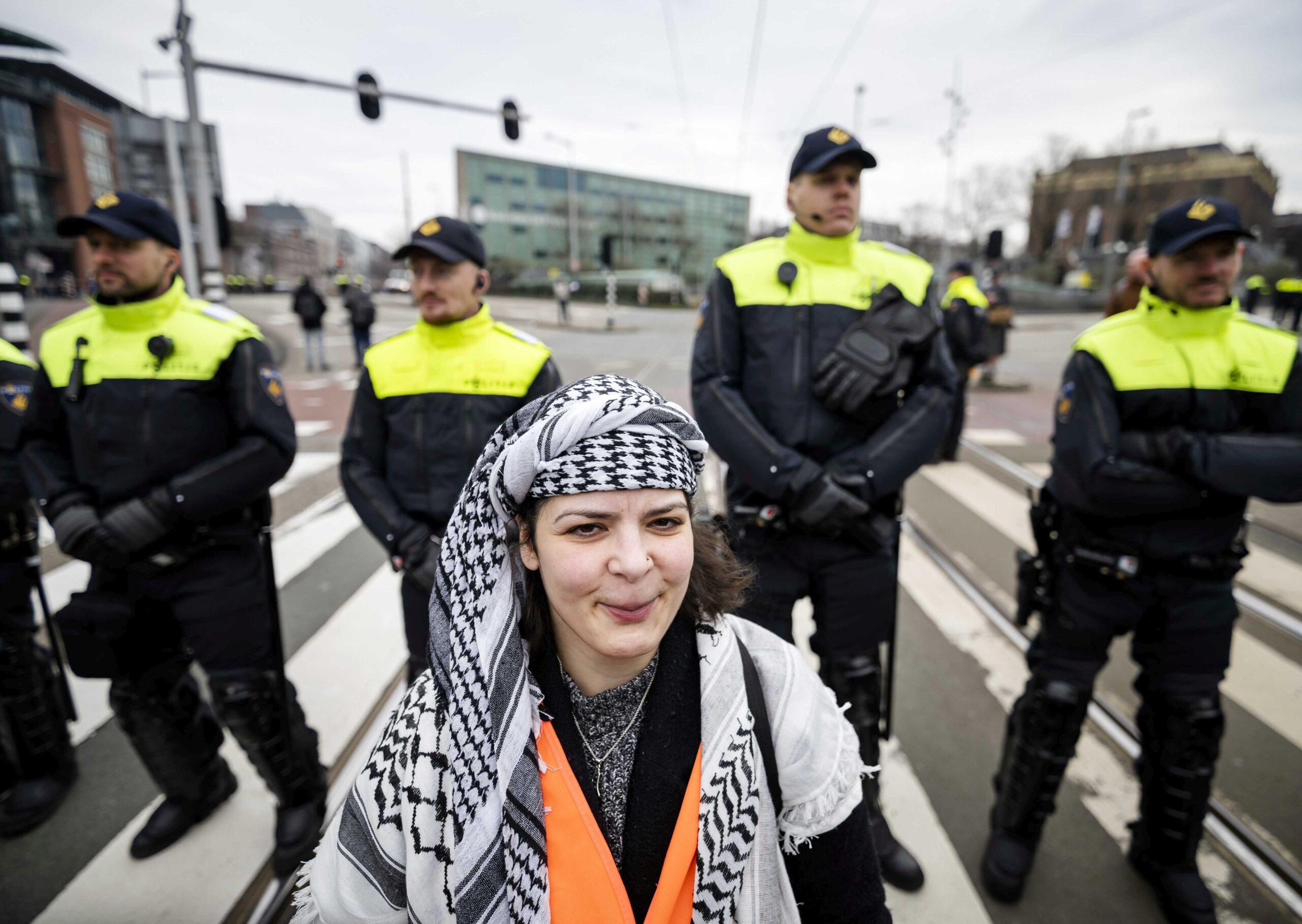 epa11210724 Police officers keep watch as protesters gather during a demonstration on the day of the opening of the National Holocaust Museum in Amsterdam, The Netherlands, 10 March 2024. King Willem-Alexander will open the National Holocaust Museum in Amsterdam. The demonstration is against Israeli President Isaac Herzog's attendance at the museum's opening.  EPA/FREEK VAN DEN BERGH