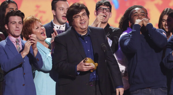 FILE - In this March 29, 2014, file photo, Dan Schneider, center, accepts the lifetime achievement award at the 27th annual Kids' Choice Awards at the Galen Center in Los Angeles. Nickelodeon is breaking ties with Schneider, the creator of some of its top shows, including “Henry Danger” and “iCarly.” In a joint statement, Nickelodeon, Schneider and his production company, Schneider’s Bakery, agreed it “is a natural time” to pursue other opportunities and projects since several Schneider’s Bakery projects are wrapping up. (Photo by Matt Sayles/Invision/AP, File)
