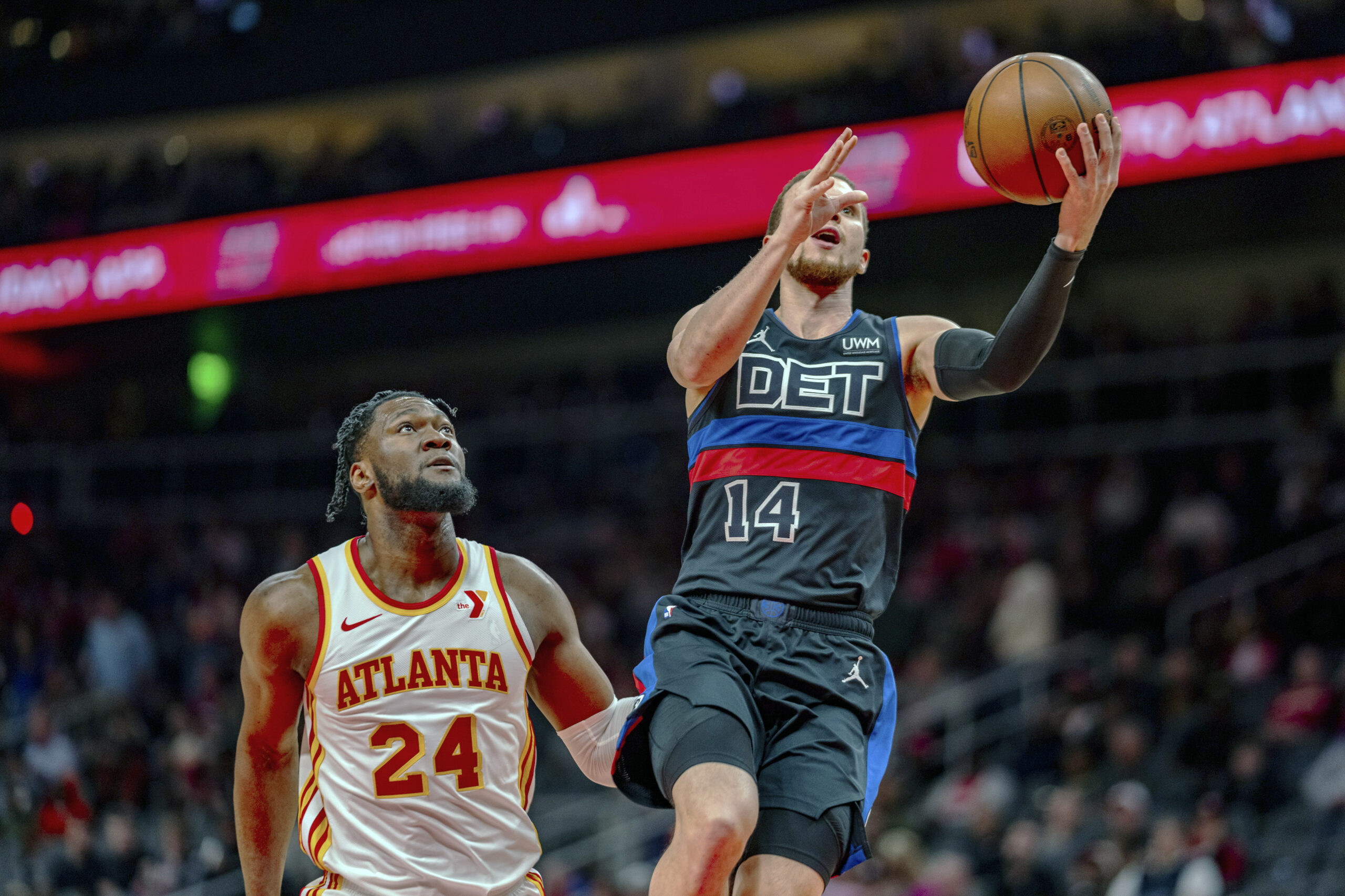 Detroit Pistons point guard Malachi Flynn (14) goes up for a layup against Atlanta Hawks forward Bruno Fernando (24) during the first half of an NBA basketball game, Wednesday, April 3, 2024, in Atlanta. (AP Photo/Jason Allen)