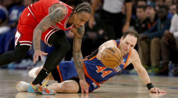 Chicago Bulls guard DeMar DeRozan, left, and New York Knicks forward Bojan Bogdanovic, right, dive for a loose ball during the second half of an NBA basketball game, Sunday, April 14, 2024, in New York. (AP Photo/John Munson)