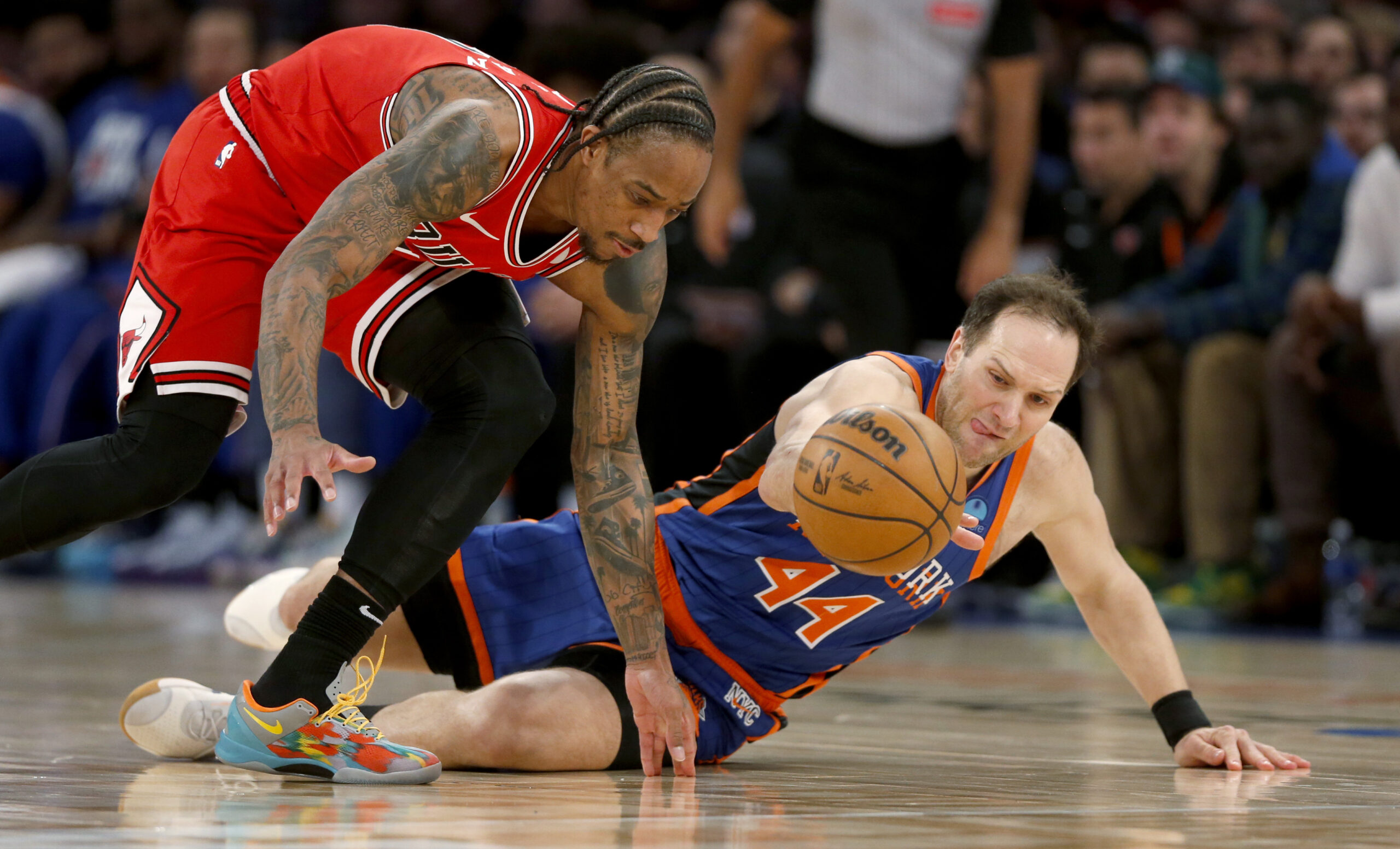 Chicago Bulls guard DeMar DeRozan, left, and New York Knicks forward Bojan Bogdanovic, right, dive for a loose ball during the second half of an NBA basketball game, Sunday, April 14, 2024, in New York. (AP Photo/John Munson)