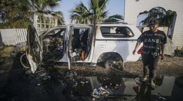 epa11255137 A man stands near a destroyed car of the NGO World Central Kitchen (WCK) along Al Rashid road, between Deir Al Balah and Khan Younis in the southern Gaza Strip, 02 April 2024. According to the Palestinian Red Crescent, at least four people from the NGO World Central Kitchen (WCK) were killed when a missile hit their convoy in Deir al Balah while they were on their way from Rafah to Gaza City to receive fresh aid delivered by the Open Arms vessel. The victims were confirmed to be a British, a Polish and an Australian citizen, while the nationality of the fourth victim was still unknown.  EPA/MOHAMMED SABER