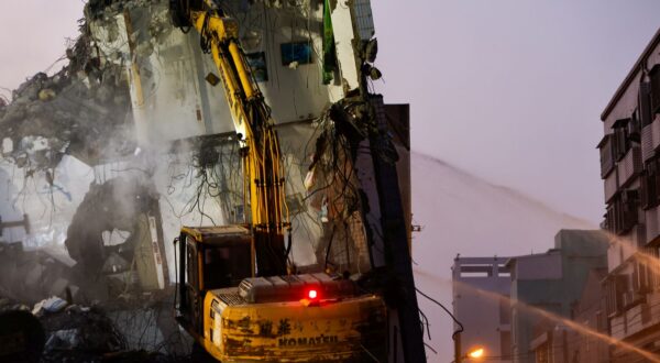 epa11257844 Firefighters spray water while an excavator demolishes the wreckage of a collapsed residential building following the 03 April magnitude 7.4 earthquake in Hualien, Taiwan, 04 April 2024. According to data released by Taiwan's National Fire Agency, the earthquake has taken at least nine lives and injured hundreds, making it the strongest earthquake in 25 years.  EPA/DANIEL CENG