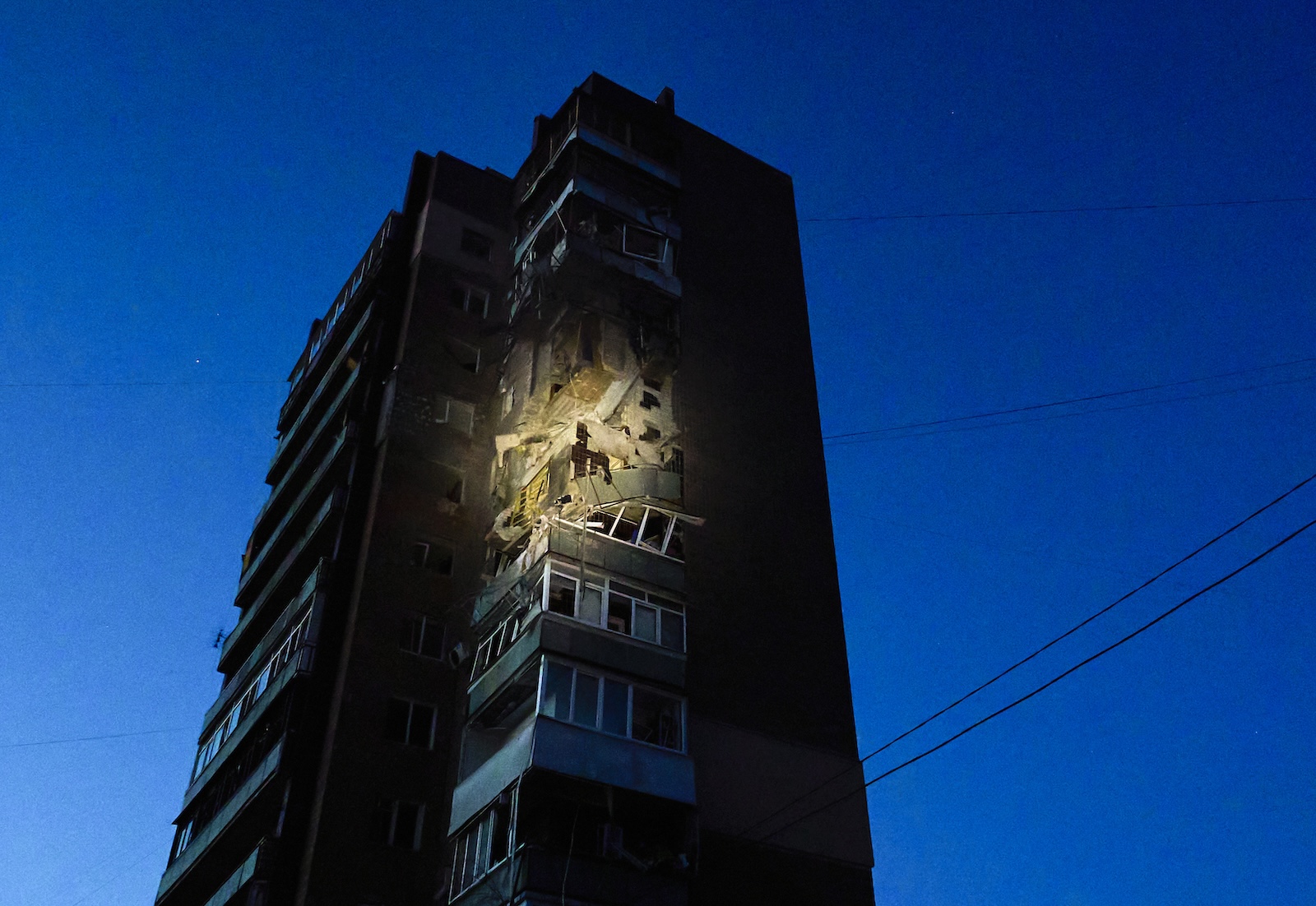 epa11258285 Damage is visible at the scene of an overnight drone attack on a residential building in Kharkiv, northeastern Ukraine, 04 April 2024, amid the Russian invasion. At least four people were killed, including three rescuers, and 11 wounded in the drone attack, according to a National Police report. Around 15 drones in total were launched by Russia over the city of Kharkiv, and some of them were shot down by air defense forces, according to the head of the Kharkiv Military Administration Oleg Synegubov. Russian troops entered Ukrainian territory on 24 February 2022, starting a conflict that has provoked destruction and a humanitarian crisis.  EPA/SERGEY KOZLOV