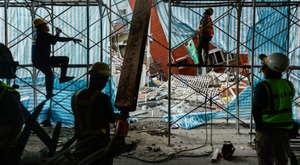 epa11261851 Workers climb up the scaffolding as they demolish the partially collapsed residential building Uranus, following the 03 April earthquake in Hualien, Taiwan, 06 April 2024. Although the government has been working to restore the city after the strongest earthquake in 25 years, the business and tourist sectors in Hualien have been affected, resulting in significant economic losses.  EPA/DANIEL CENG