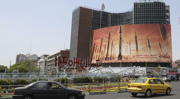 epa11279808 Iranians drive past an anti-Israel billboard carrying pictures of Iranian missiles in Tehran, Iran, 15 April 2024. Iran's Islamic Revolutionary Guards Corps (IRGC) launched drones and rockets towards Israel late on 13 April 2024, Iranian officials said.  EPA/ABEDIN TAHERKENAREH