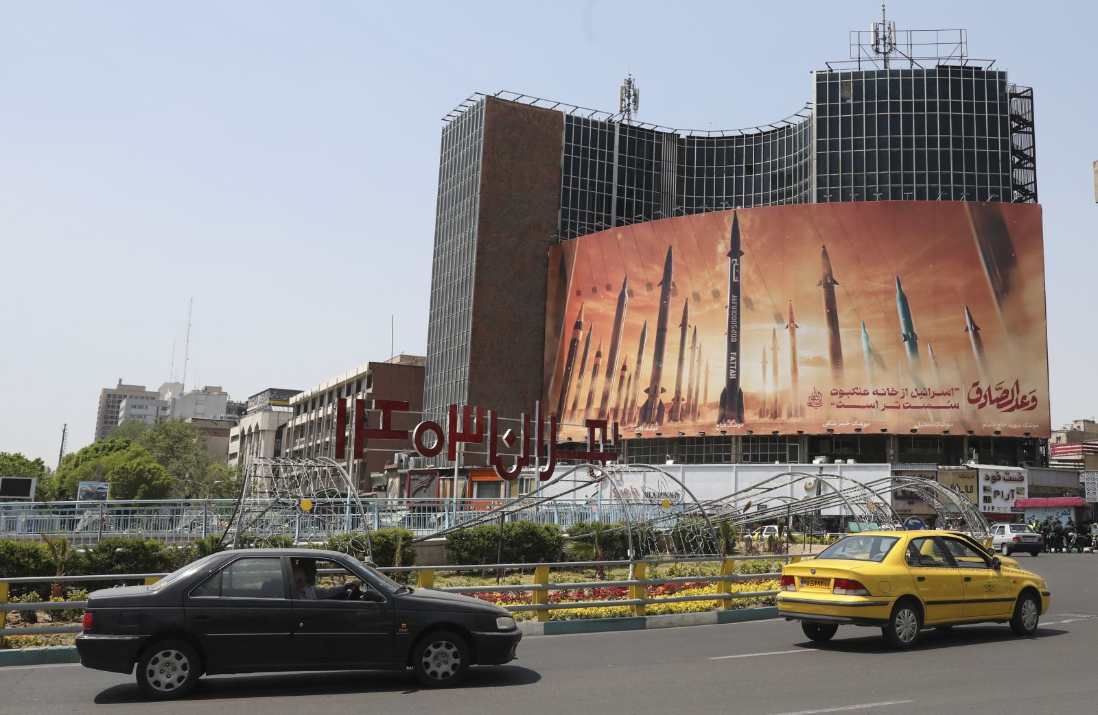 epa11279808 Iranians drive past an anti-Israel billboard carrying pictures of Iranian missiles in Tehran, Iran, 15 April 2024. Iran's Islamic Revolutionary Guards Corps (IRGC) launched drones and rockets towards Israel late on 13 April 2024, Iranian officials said.  EPA/ABEDIN TAHERKENAREH