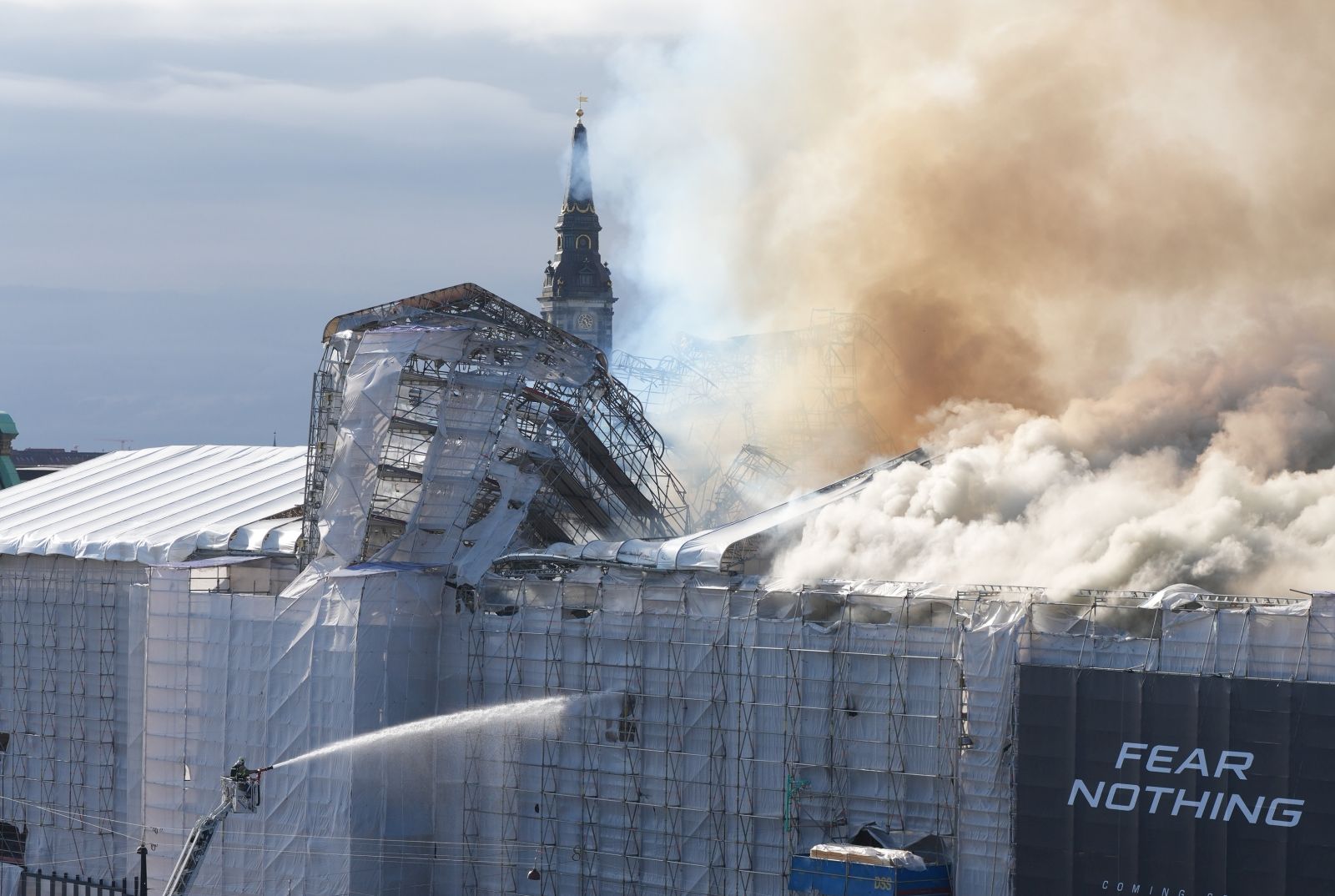 epa11281365 Firefighters work to extinguish a fire at the old Stock Exchange (Boersen) in Copenhagen, Denmark, 16 April 2024. A violent fire broke out in the building which is under renovation on the morning of 16 April. The building was erected in the 1620s as a commercial building by King Christian IV and is located next to the Danish parliament.  EPA/Emil Helms DENMARK OUT