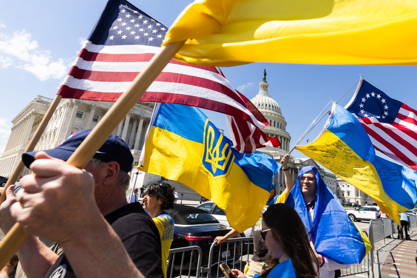 epa11290792 Supporters of Ukraine wave US and Ukrainian flags outside the US Capitol after the House approved foreign aid packages to Ukraine, as well as Israel and Taiwan in the US Capitol in Washington, DC, USA, 20 April 2024. Senate Majority Leader Chuck Schumer has vowed to advance the foreign aid packages as soon as next week.  EPA/JIM LO SCALZO
