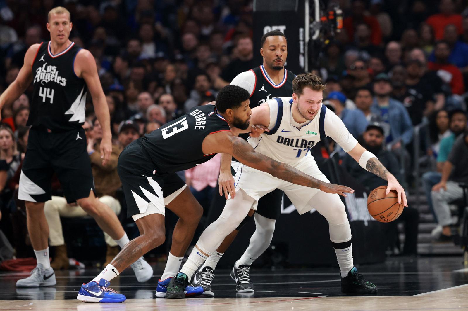 Apr 23, 2024; Los Angeles, California, USA; Dallas Mavericks guard Luka Doncic (77) is defended by Los Angeles Clippers forward Paul George (13) during the first quarter of game two of the first round for the 2024 NBA playoffs at Crypto.com Arena. Mandatory Credit: Kiyoshi Mio-USA TODAY Sports Photo: Kiyoshi Mio/REUTERS