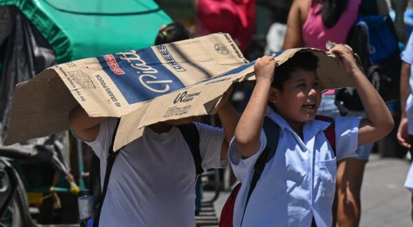 Students use a cardboard to protect themselves from the sun during a hot day in Manila on April 2, 2024.  More than a hundred schools in the Philippine capital shut their classrooms on April 2, as the tropical heat hit "danger" levels, education officials said.,Image: 861698799, License: Rights-managed, Restrictions: , Model Release: no, Credit line: JAM STA ROSA / AFP / Profimedia