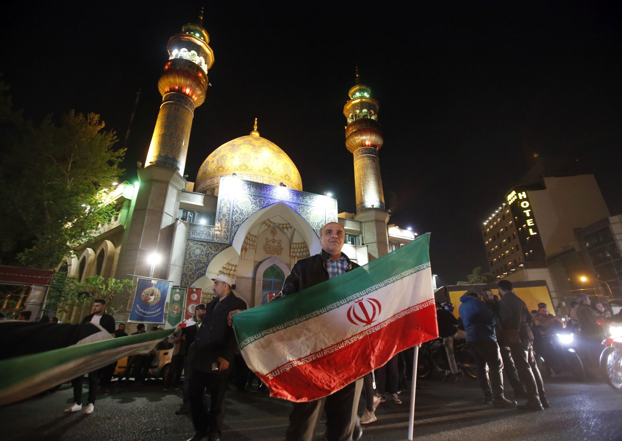 epa11277386 A man holds an Iranian flag during an anti-Israel rally after Iran launched drone attacks against Israel at Palestine Square in Tehran, Iran, early morning of 14 April 2024. Iran's Islamic Revolutionary Guards Corps (IRGC) launched drones and rockets towards Israel late on 13 April 2024, Iranian officials said.  EPA/ABEDIN TAHERKENAREH