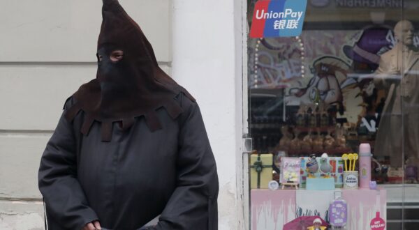 epa11284861 A man dressed as an Inquisition executioner invites pedestrians to the Museum of Torture at the Nevsky Prospect avenue in St. Petersburg, Russia, 17 April 2024.  EPA/ANATOLY MALTSEV