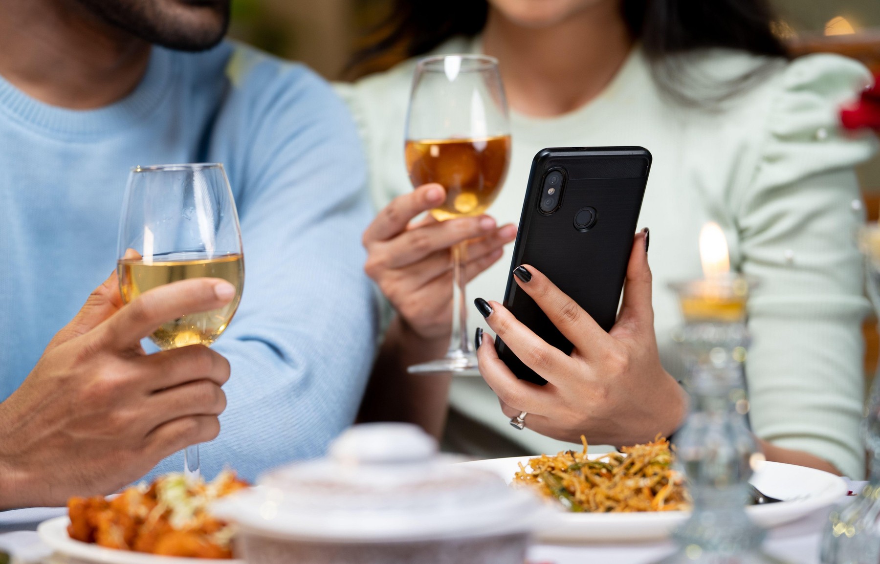 close up shot of couple hands using mobile phone by having drinks during candlelight dinner - concept of wedding anniversary celebration, cyberspace and dating application.,Image: 755088609, License: Royalty-free, Restrictions: , Model Release: no, Credit line: lakshmiprasad S / Alamy / Alamy / Profimedia