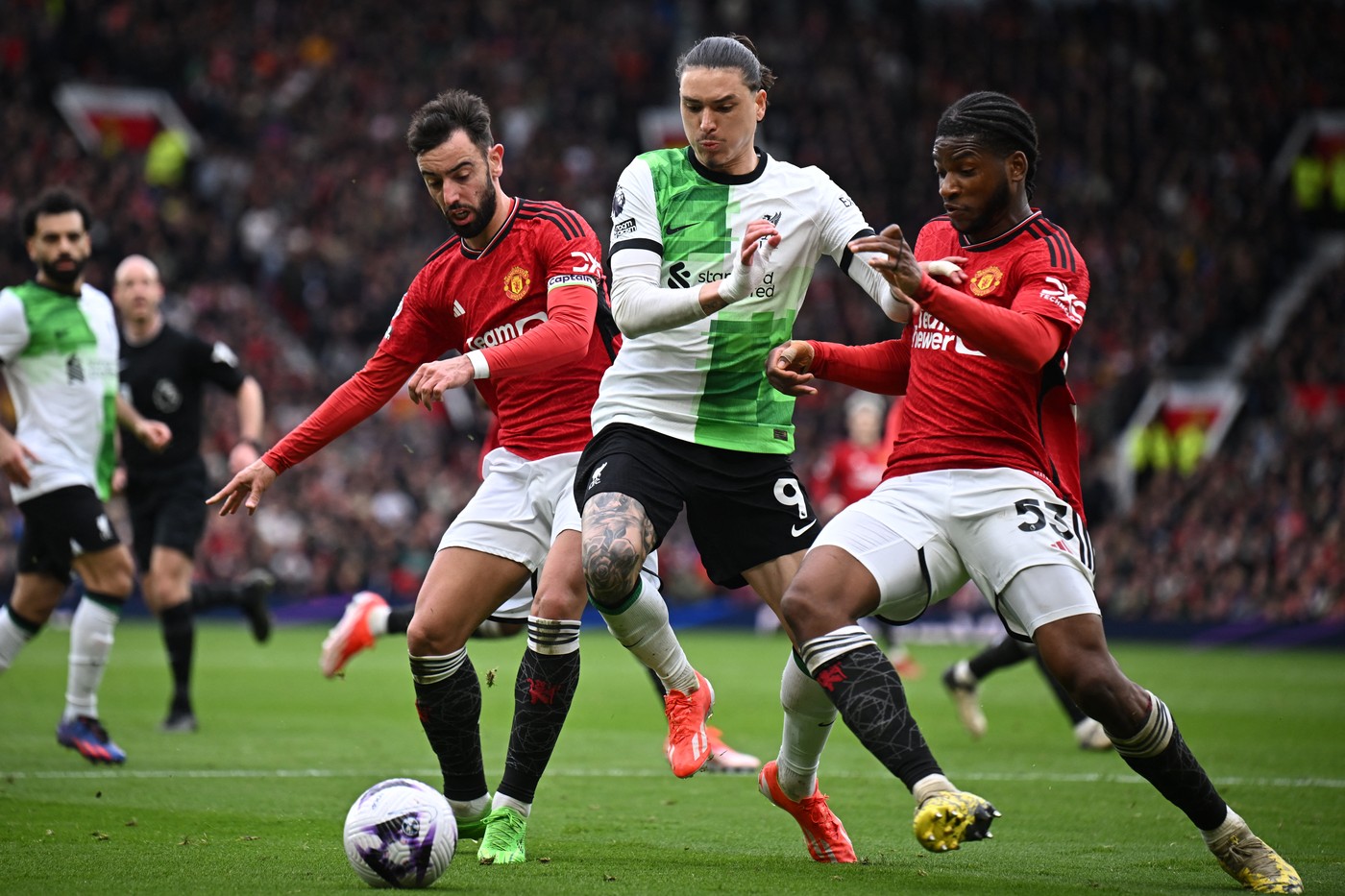 Liverpool's Uruguayan striker #09 Darwin Nunez (C) vies with Manchester United's Portuguese midfielder #08 Bruno Fernandes (L) and Manchester United's Conoglese-born French defender #53 Willy Kambwala (R) during the English Premier League football match between Manchester United and Liverpool at Old Trafford in Manchester, north west England, on April 7, 2024.,Image: 863130360, License: Rights-managed, Restrictions: RESTRICTED TO EDITORIAL USE. No use with unauthorized audio, video, data, fixture lists, club/league logos or 'live' services. Online in-match use limited to 120 images. An additional 40 images may be used in extra time. No video emulation. Social media in-match use limited to 120 images. An additional 40 images may be used in extra time. No use in betting publications, games or single club/league/player publications., Model Release: no, Credit line: Paul ELLIS / AFP / Profimedia