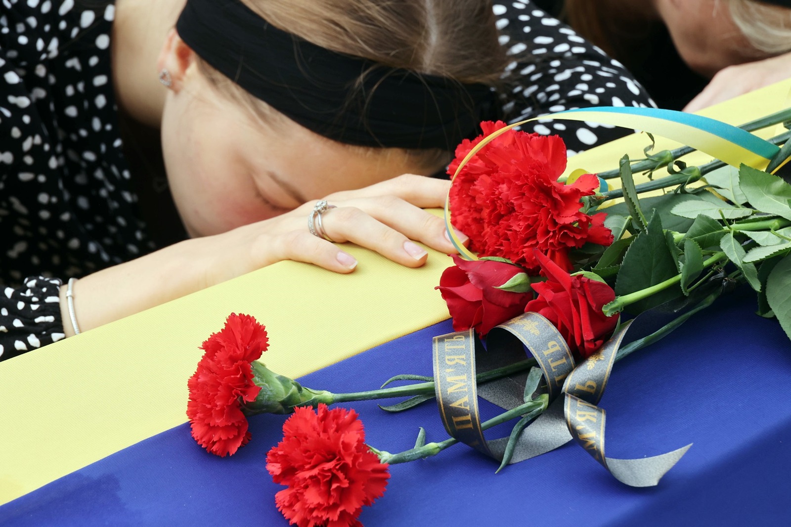 September 1, 2023, Poltava, Ukraine: A woman stays by a coffin during the funeral ceremony of pilots and technicians of two Mi-8 helicopters outside the Church of the Nativity of the Blessed Virgin Mary, Poltava, central Ukraine. Two Mi-8 helicopters crashed near Novoiavlenka village, Donetsk Region, while on a combat mission on Tuesday, August 29. Four pilots and two technicians of the 18th Igor Sikorsky Separate Army Aviation Brigade died in the accident.,Image: 802056304, License: Rights-managed, Restrictions: , Model Release: no, Credit line: Vyacheslav Madiyevskyy / Zuma Press / Profimedia