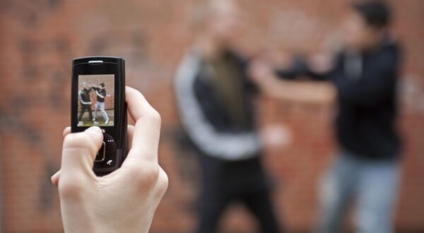 Two boys fighting on the playground while a third films with his cell phone, posed scene,Image: 88633794, License: Rights-managed, Restrictions: , Model Release: yes, Credit line: Siegfried Kuttig / imageBROKER / Profimedia