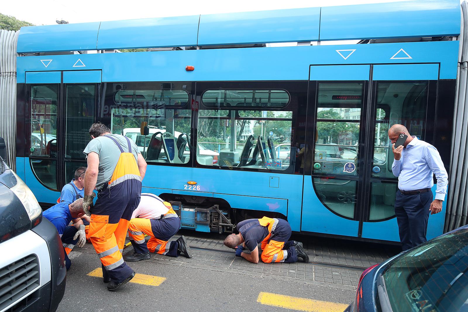 30.08.2022., Zagreb - Tramvaj na Savskoj cesti neposredno prije krizanja s Vukovarskom avenijom iskocio je iz tracnica. Tramvajski promet u smjeru juga je u prekidu, a stvaraju se guzve u prometu Savskom prema jugu. Radnici ZET-a izasli su na mjesto nezgode kako bi ubacili tramvaj ponovno na tracnice, dok policijski sluzbenici reguliraju promet kako bi smanjili guzve.  Photo: Goran Stanzl/PIXSELL