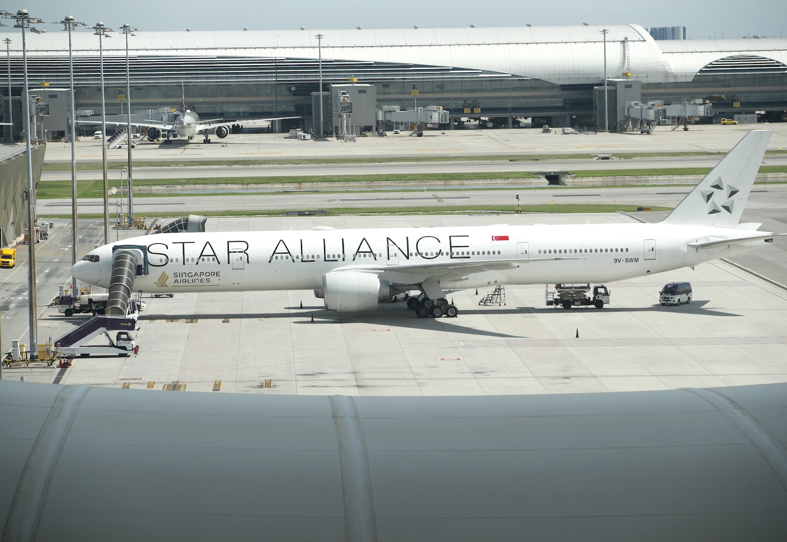 epa11359841 A photo taken through window glass of an aircraft observation deck shows a Singapore Airlines plane flight from London to Singapore parked one day after diverting an emergency landing at Suvarnabhumi International Airport in Samut Prakan province, Thailand, 22 May 2024. According to Singapore Airlines, at least one person died and more than 30 passengers were injured when a Singapore Airlines plane traveling from London to Singapore was diverted to Bangkok in an emergency due to severe turbulence.  EPA/RUNGROJ YONGRIT