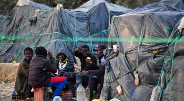 Migrants from sub-Saharan Africa sit next to makeshift shelters at a camp al-Amra on the outskirts of the Tunisian port city of Sfax on April 23, 2024. After President Kais Saied said in a speech last year that "hordes of illegal migrants" posed a demographic threat to Tunisia, anti-migrant violence broke out and hundreds of sub-Saharan Africans were kicked out of their jobs and homes.,Image: 867348527, License: Rights-managed, Restrictions: TO GO WITH: Tunisia-migration-rights FOCUS by Francoise KADRI, Model Release: no, Credit line: Fethi Belaid / AFP / Profimedia