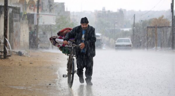 A displaced Palestinian man pushes a bycicle bearing his belongings in the rain in Rafah in the southern Gaza Strip following an evacuation order by the Israeli army on May 6, 2024, amid the ongoing conflict between Israel and the Palestinian Hamas movement.,Image: 870590635, License: Rights-managed, Restrictions: , Model Release: no, Credit line: AFP / AFP / Profimedia