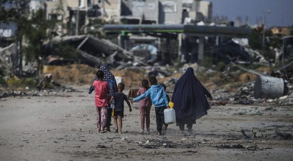 epaselect epa11392513 Internally displaced Palestinians walk next to destroyed buildings in Khan Younis, southern Gaza Strip, 05 June 2024. More than 36,000 Palestinians and over 1,400 Israelis have been killed, according to the Palestinian Health Ministry and the Israel Defense Forces (IDF), since Hamas militants launched an attack against Israel from the Gaza Strip on 07 October 2023, and the Israeli operations in Gaza and the West Bank which followed it.  EPA/MOHAMMED SABER