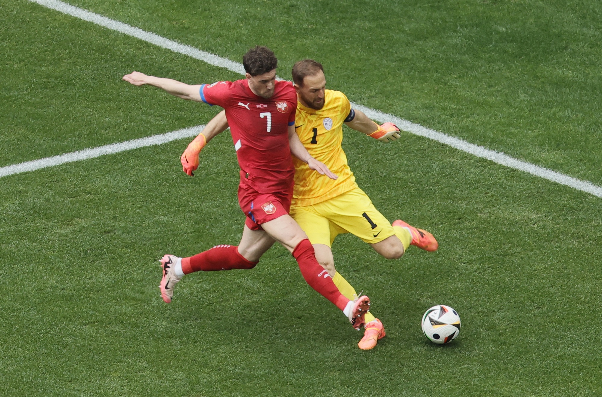 epa11425124 Dusan Vlahovic of Serbia (L) and goalkeeper Jan Oblak of Slovenia in action during the UEFA EURO 2024 Group C soccer match between Slovenia and Serbia, in Munich, Germany, 20 June 2024.  EPA/RONALD WITTEK