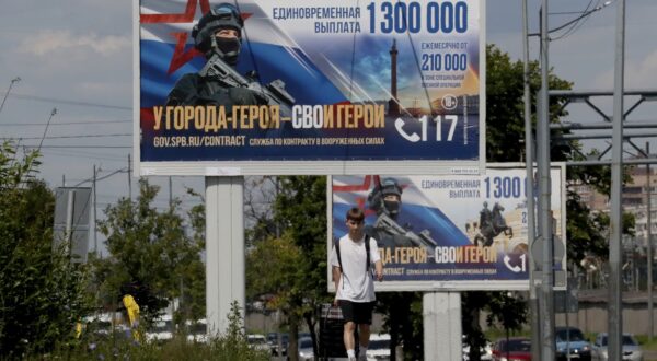 epa11436129 A man walks in front of billboards advertising to join military service with the slogan 'A heroic city has its heroes' in St. Petersburg, Russia, 25 June 2024.  EPA/ANATOLY MALTSEV