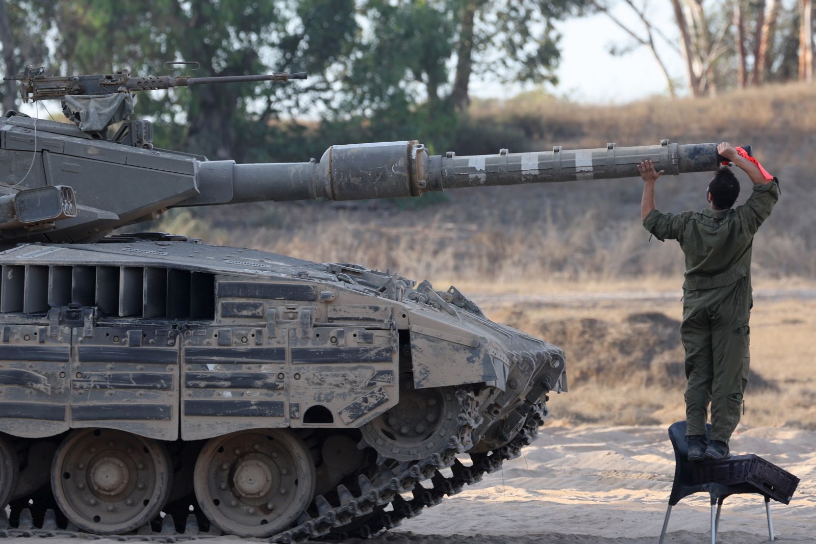 epa11408289 An Israeli soldier inspects the cannon of a tank at an undisclosed location near the border with the Gaza Strip, in southern Israel, 13 June 2024. The Israeli military stated on 13 June that its troops are continuing to operate against 'terrorist infrastructure and operatives' in the Gaza Strip. More than 37,000 Palestinians and over 1,400 Israelis have been killed, according to the Palestinian Health Ministry and the Israel Defense Forces (IDF), since Hamas militants launched an attack against Israel from the Gaza Strip on 07 October 2023, and the Israeli operations in Gaza and the West Bank which followed it.  EPA/ABIR SULTAN