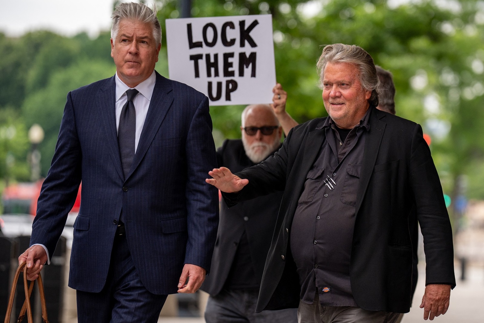 WASHINGTON, DC - JUNE 6: A man holds a sign that reads "Lock Them Up" as Attorney Matthew Evan Corcoran (L) and Steve Bannon, former advisor to President Donald Trump, depart federal court on June 6, 2024 in Washington, DC. Bannon has been ordered to begin serving his four-month prison sentence on July 1 for two counts of contempt of Congress after failing to comply with a congressional subpoena related to the Jan. 6, 2021, attack on the U.S. Capitol.   Andrew Harnik,Image: 879436414, License: Rights-managed, Restrictions: , Model Release: no, Credit line: Andrew Harnik / Getty images / Profimedia