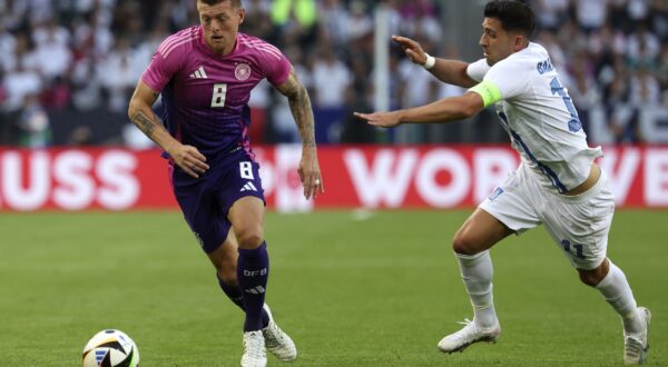 epa11396498 Toni Kroos of Germany (L) in action against Anastasios Bakasetas of Greece (R) during the international friendly soccer match between Germany and Greece in Moenchengladbach, Germany, 07 June 2024.  EPA/CHRISTOPHER NEUNDORF