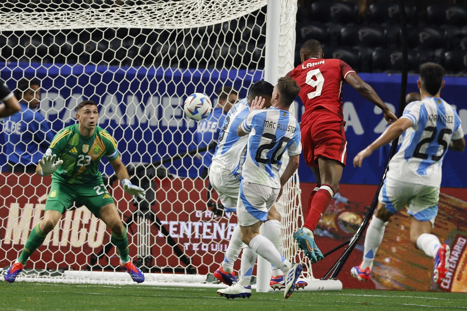 epa11427124 Cyle Larin (2-R) of Canada takes a shot on Emiliano Martinez (L) of Argentina during the second half of the CONMEBOL Copa America 2024 group A soccer match between Argentina and Canada, in Atlanta, Georgia, USA, 20 June 2024.  EPA/ERIK S. LESSER