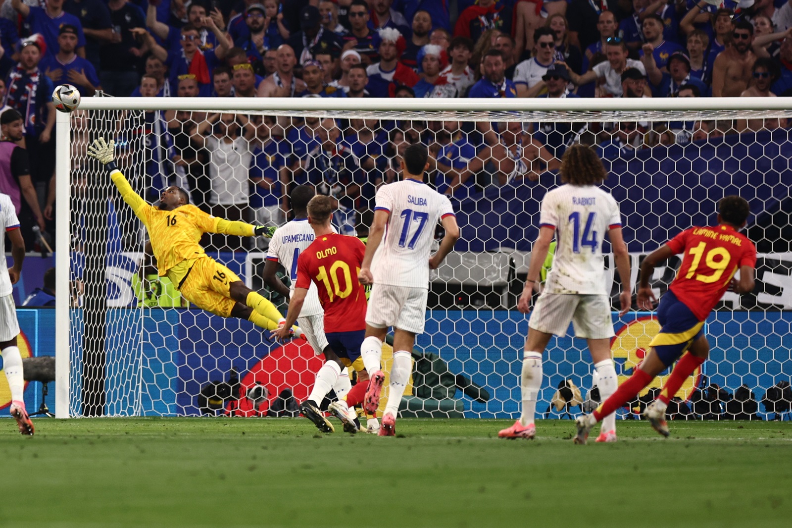 epa11468902 Lamine Yamal of Spain (R) scores the 1-1 goal against goalkeeper Mike Maignan of France (L) during the UEFA EURO 2024 semi-finals soccer match between Spain and France in Munich, Germany, 09 July 2024.  EPA/ANNA SZILAGYI