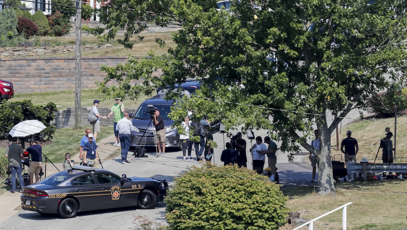 epa11477678 Law enforcement officials and members of the media near the home of 20-year-old Thomas Matthew Crooks, identified by the Federal Bureau of Investigation (FBI) as the person who attempted to assassinate former president Donald J. Trump, during an investigation in Bethel Park, Pennsylvania, USA, 14 July 2024. Crooks was killed by police after shooting and injuring Trump during a rally in Butler, Pennsylvania on 13 July.  EPA/DAVID MAXWELL