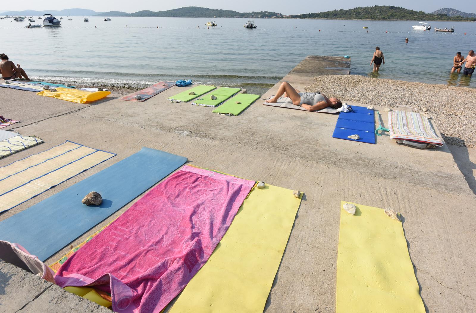 14.08.2015., Vodice - Duz plaza na Srimi i u Vodicama komunalno redarstvo grada postavilo je oznake upozorenja da se preko noci i rano ujutro radi rezerviranja mjesta na plazi ne ostvaljaju rucnici i osobne stvari. U koliko se turisti ne budu pridrzavali upozorenja stvari ce biti uklonjene. Photo: Hrvoje Jelavic/PIXSELL