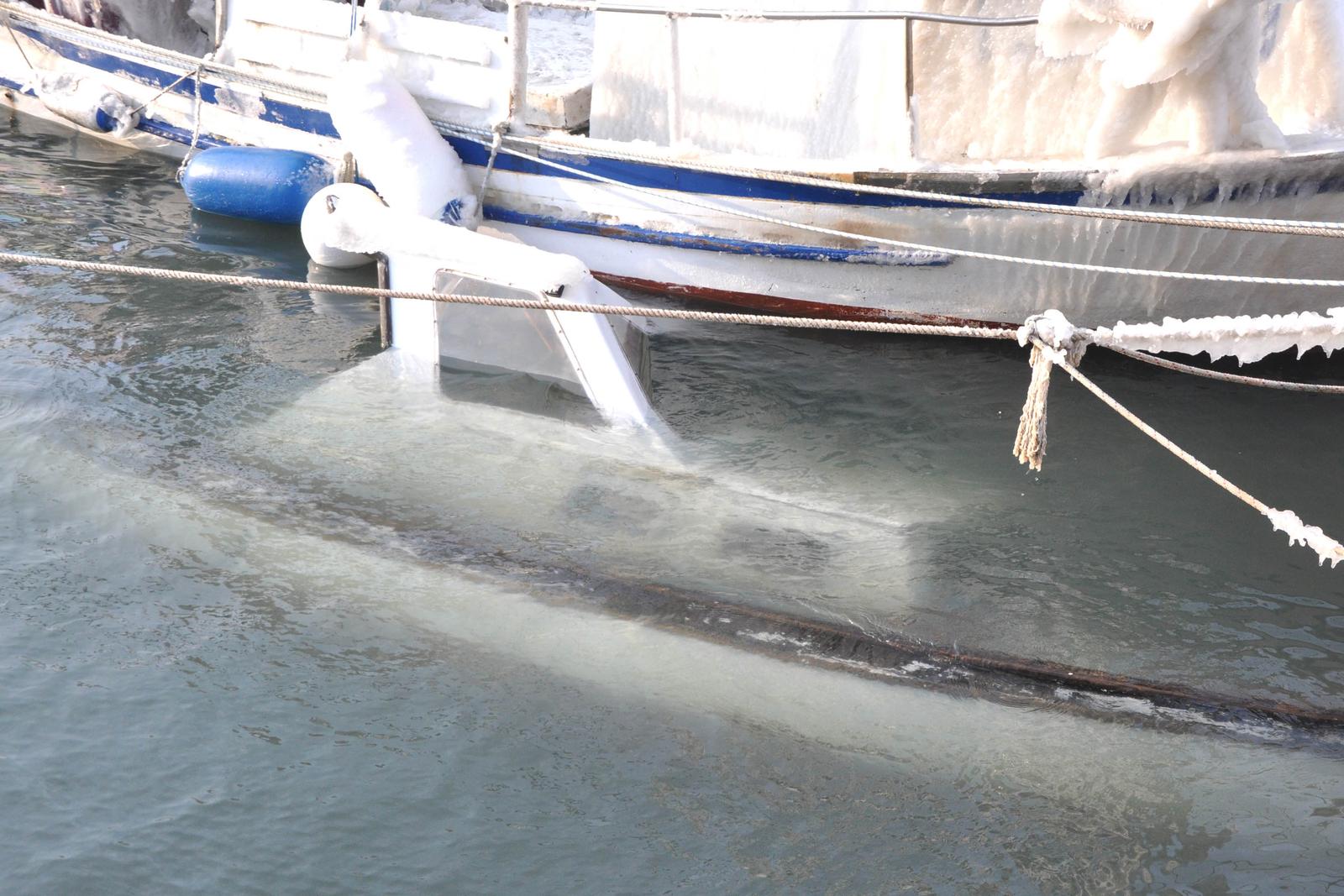11.02.2012., Premantura - U zaljevu Runke u Premanturi vise brodica i jedan veci gliser te potopljeno je tik uz molo. Nasuprot uvale jedna jedrilica nasukana je na hridi. "nPhoto: Dusko Marusic/PIXSELL