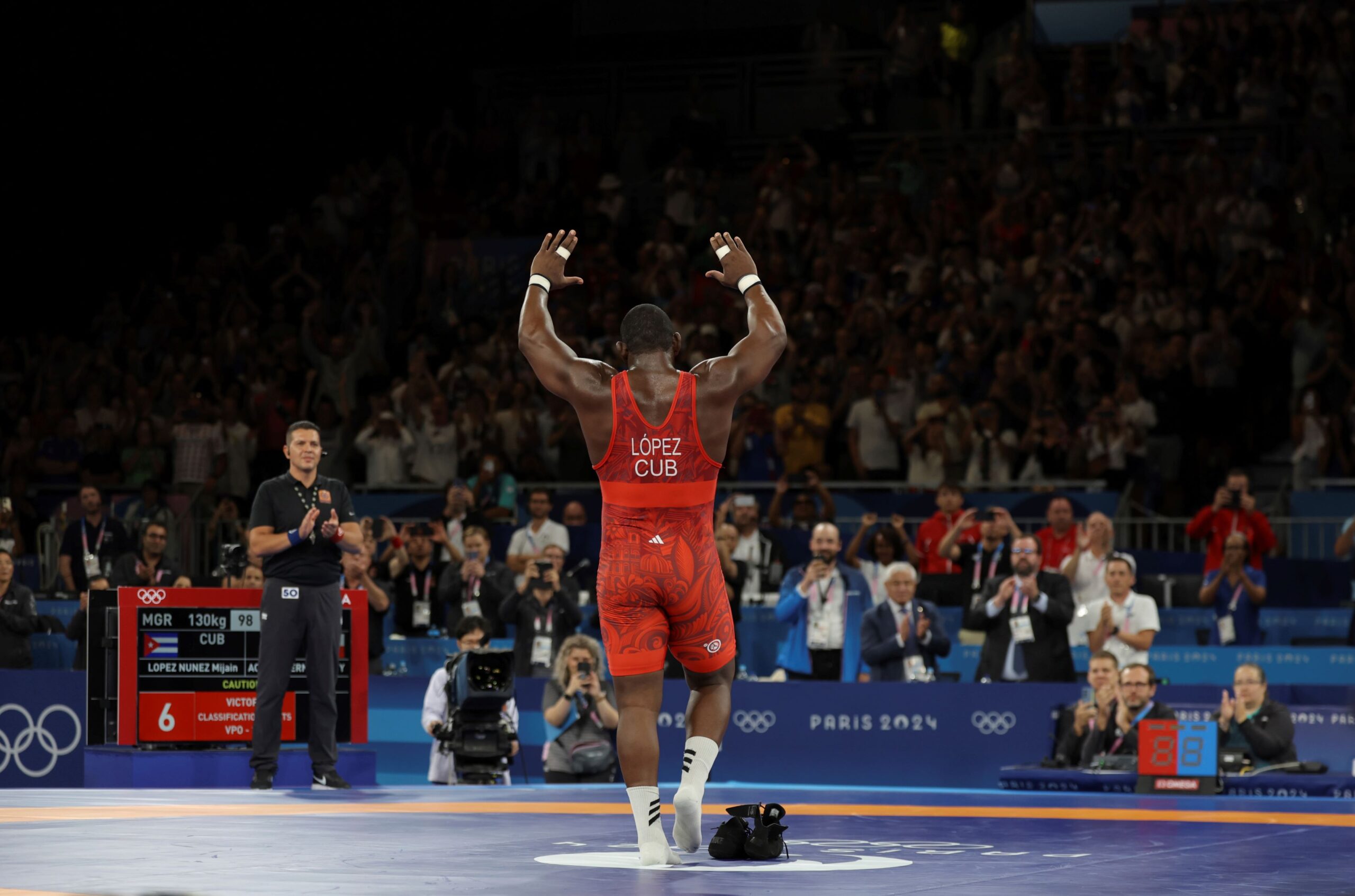 Cuba's LOPEZ NUNEZ Mijain leaves his shoes on a mat after winning the Men's Greco-Roman 130kg Final against Chile's ACOSTA FERNANDEZ Yasmani in the Paris Olympics at the Paris Olympics at the Champ de Mars Arena