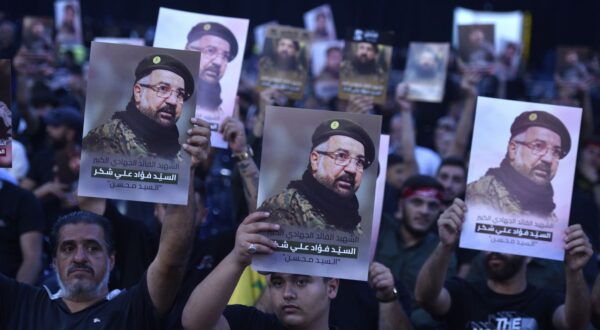 epa11515825 Mourners hold pictures as they attend the funeral procession for late senior Hezbollah commander Fuad Shukr, killed in an Israeli strike, in Beirut, Lebanon, 01 August 2024. Hezbollah and the Israel Defense Forces (IDF) confirmed that Shukr was killed in an Israeli strike on 30 July in the Haret Hreik neighborhood of Beirut. Lebanon's state media said at least four people were killed.  EPA/WAEL HAMZEH
