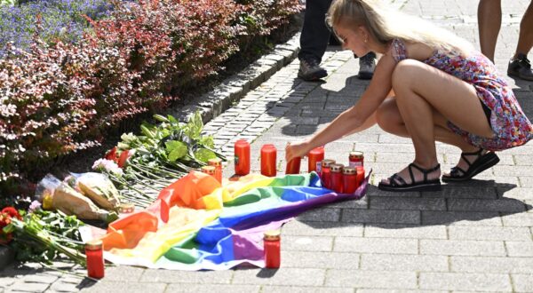 A young woman lights a candle at a makeshift memorial of flowers and a rainbow flag for the victims on August 24, 2024 close to the scene where at least three people were killed and several injured when a man attacked them with a knife on late August 23, 2024 in Solingen, western Germany, during a festival to mark the city's 650th anniversary. German police stepped up a major hunt for a man who stabbed three people to death and wounded eight others at the street festival, authorities said. Police closed off the centre of Solingen after the attack at the city's "Festival of Diversity". A police statement said five of the wounded were in "serious" condition.,Image: 901184603, License: Rights-managed, Restrictions: , Model Release: no, Credit line: Roberto Pfeil / AFP / Profimedia