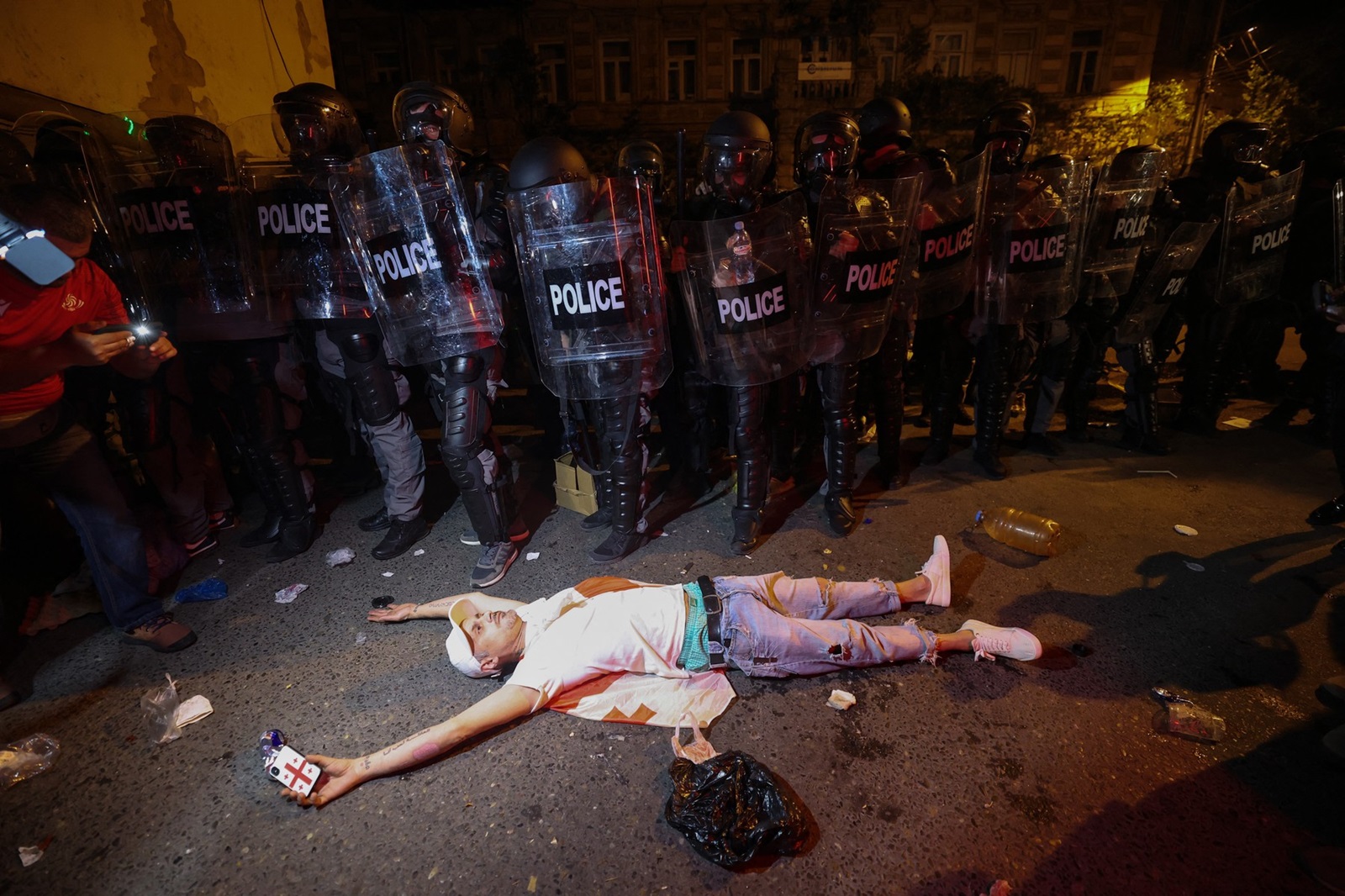 A protester lies on the ground in front of riot police during a rally against a controversial "foreign influence" bill, which Brussels warns would undermine Georgia's European aspirations, outside the Georgian parliament in Tbilisi on April 30, 2024.,Image: 869193775, License: Rights-managed, Restrictions: , Model Release: no, Credit line: Giorgi ARJEVANIDZE / AFP / Profimedia