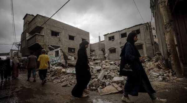 epa11635336 Palestinians walk past a destroyed house following an Israeli air strike in Al Nusairat refugee camp, central Gaza Strip, 01 October 2024. More than 41,000 Palestinians and over 1,400 Israelis have been killed, according to the Palestinian Health Ministry and the Israel Defense Forces (IDF), since Hamas militants launched an attack against Israel from the Gaza Strip on 07 October 2023, and the Israeli operations in Gaza and the West Bank which followed it.  EPA/MOHAMMED SABER