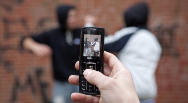 Two boys fighting on the playground while a third films with his cell phone, posed scene,Image: 88633793, License: Rights-managed, Restrictions: , Model Release: yes, Credit line: Siegfried Kuttig / imageBROKER / Profimedia