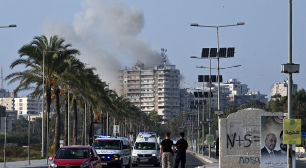 epa11707568 Smoke rises following an Israeli airstrike as ambulances transport the coffins of 16 people who were killed in an Israeli strike in the town of Barja, during the funeral in the southern port city of Tyre, Lebanon, 07 November 2024. At least 20 people were killed as a result of an Israeli airstrike on a residential building in Barja late on 05 November, the Lebanese Ministry of Health said. According to the Lebanese Ministry of Health, more than 3,000 people have been killed and over 13,600 others injured in Lebanon since the escalation in hostilities between Israel and Hezbollah.  EPA/STR